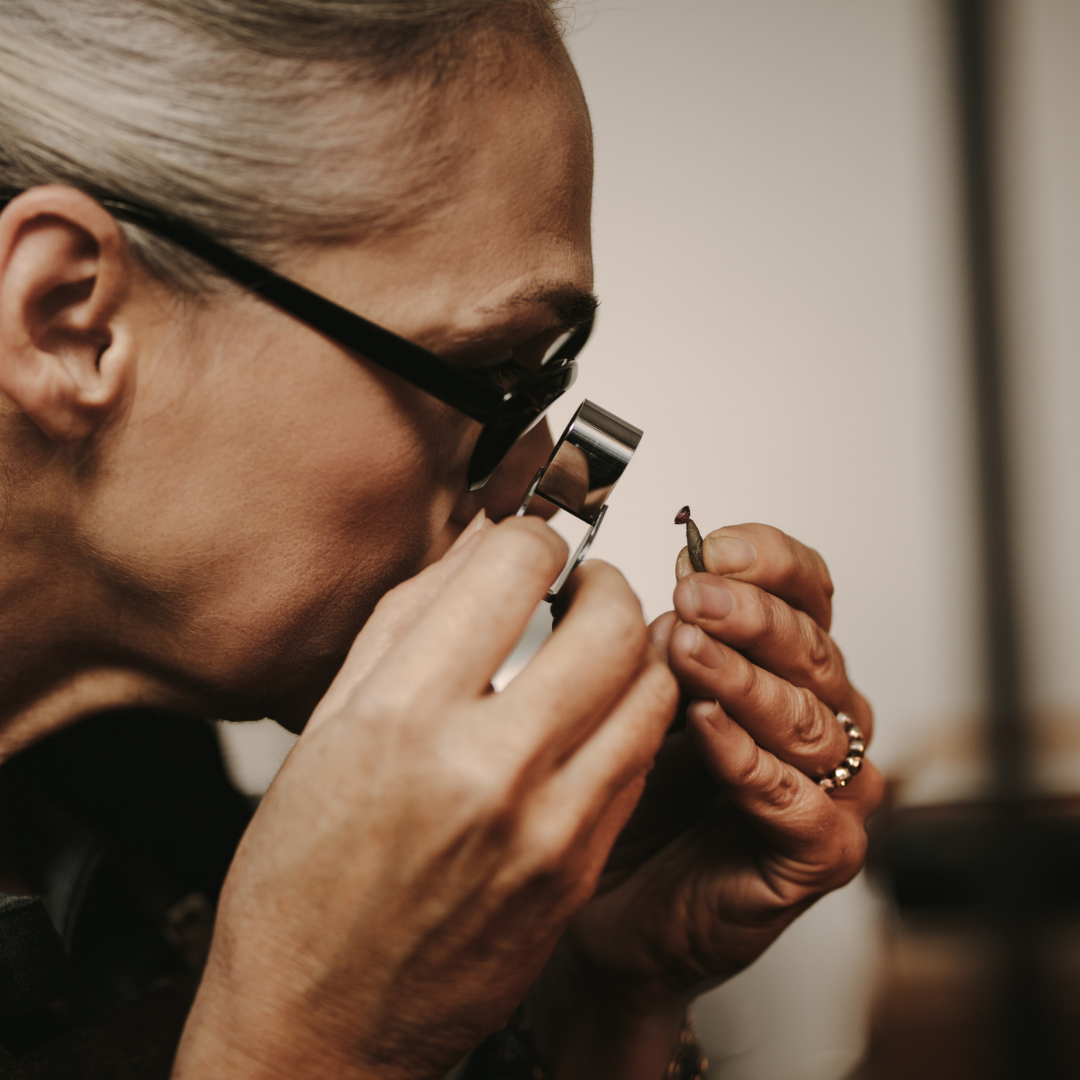 woman looking at diamond through loupe